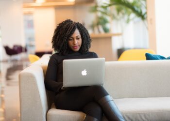Woman Using Macbook Sitting on White Couch | GRAMHIR