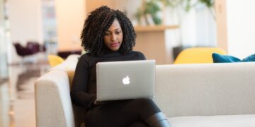 Woman Using Macbook Sitting on White Couch | GRAMHIR