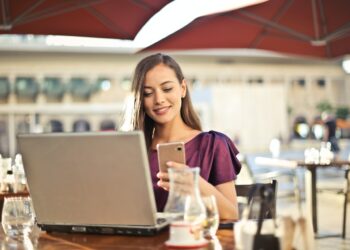 Woman Wearing Purple Shirt Holding Smartphone White Sitting on Chair | GRAMHIR