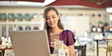 Woman Wearing Purple Shirt Holding Smartphone White Sitting on Chair | GRAMHIR