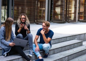 Three Persons Sitting on the Stairs Talking With Each Other | GRAMHIR