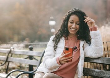 Cheerful Latin American woman with smartphone | GRAMHIR