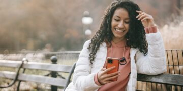 Cheerful Latin American woman with smartphone | GRAMHIR