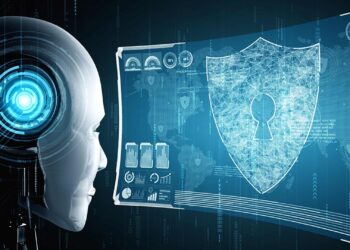 A robotic head with a glowing blue eye looks at a digital interface displaying a shield with a keyhole, representing AI in cybersecurity. The background features various tech symbols and data, emphasizing the theme of artificial intelligence and data protection. | GRAMHIR