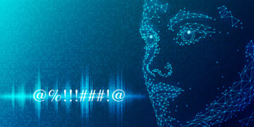 A digital, polygonal face made of interconnected blue dots and lines is shown on a dark blue background. The face appears to be gazing towards a series of abstract symbols (@%..!!##!@). Soundwave and digital binary patterns, evoking ai voice cloning technology, are visible in the background. | GRAMHIR