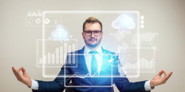 A man in a suit sits at a desk in a meditation pose, eyes open, with digital graphs, AiSDR, and cloud computing icons floating before him, representing calm and control in a high-tech business environment. | GRAMHIR