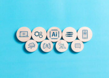 Nine wooden circles on a blue background, each with a different AI-related icon, including gears, a computer, cloud, robot arms, server, and speech bubble, representing various aspects of artificial intelligence. | GRAMHIR