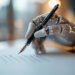 A robotic hand holding a pen writes on a sheet of paper, with soft, blurred lights in the background. | GRAMHIR